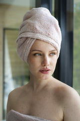 Woman with a towel wrapped around her head in a bathroom setting