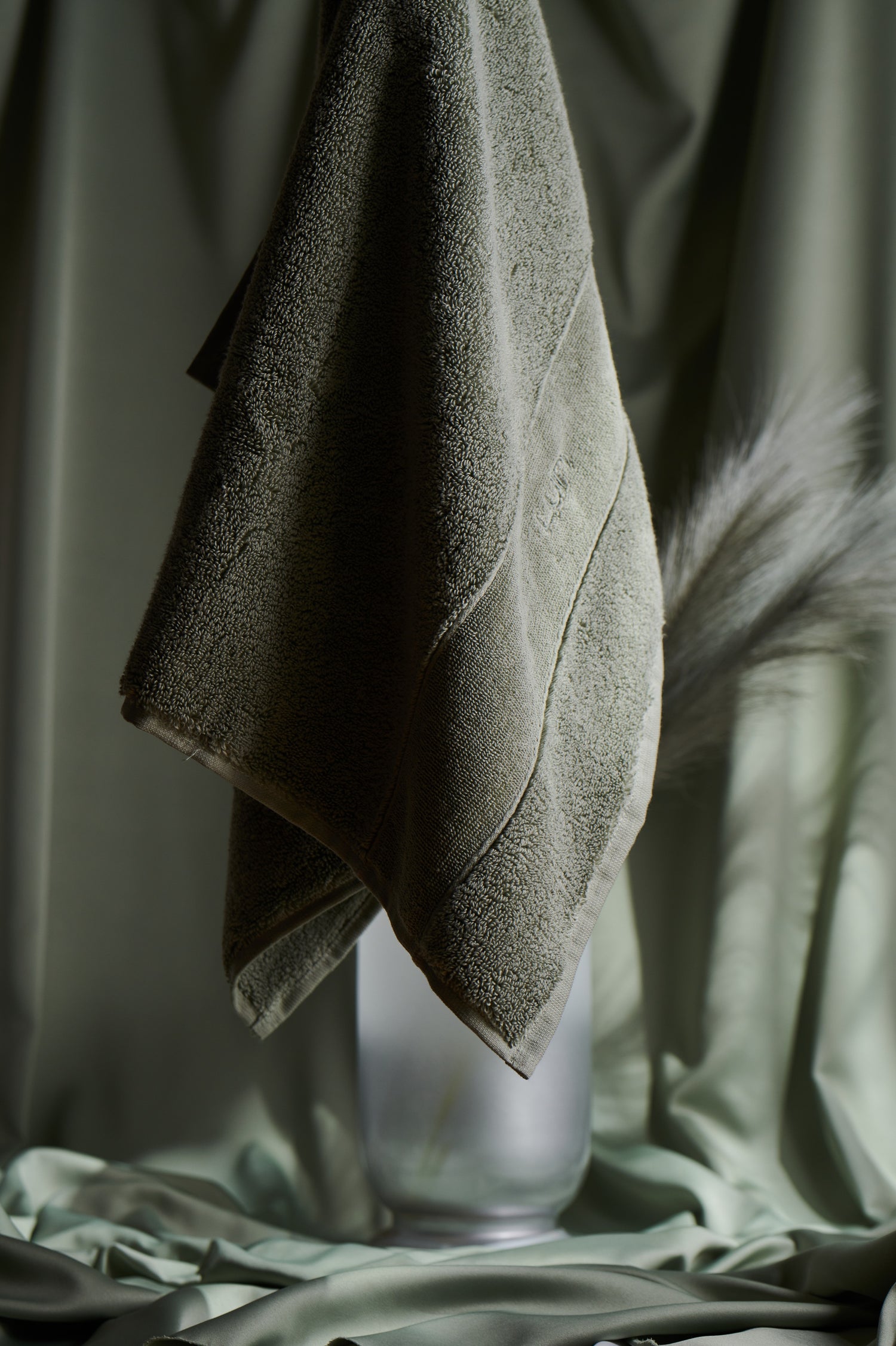 Green towel hanging against a blurred green background