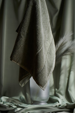 Green towel hanging against a blurred green background